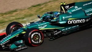 Green Formula 1-style race car speeding on a track with sponsor logos on the bodyplate.