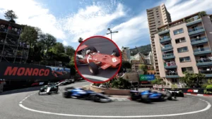 Racing cars speed around a tight corner at Monaco street circuit with city buildings in the background.