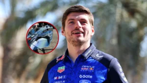Portrait of a male race driver in a blue sponsor racing suit outdoors, with an inset circle showing a close-up of his helmet.