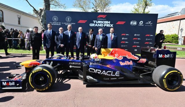 Red Bull Formula 1 car on display with officials and photographers at the Turkish Grand Prix 2027 backdrop in a sunny area.