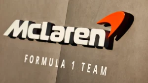 McLaren Formula 1 Team logo with orange swoosh on a wall.
