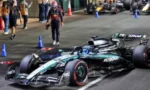 Formula 1 car from Mercedes-Petronas team parked on a street circuit with pit crew and cones nearby, ready for a practice run.",