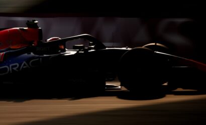 Silhouetted Formula 1 car in motion on the track, with Oracle branding visible on the side.