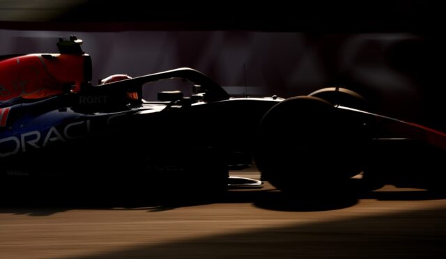 Silhouetted Formula 1 car in motion on the track, with Oracle branding visible on the side.