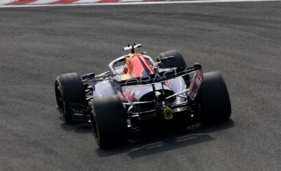 Red Bull Racing Formula 1 car seen from behind on a racetrack, the Oracle branding on the rear wing visible as it rounds a corner.