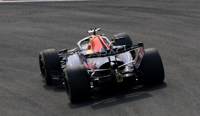 Red Bull Racing Formula 1 car seen from behind on a racetrack, the Oracle branding on the rear wing visible as it rounds a corner.