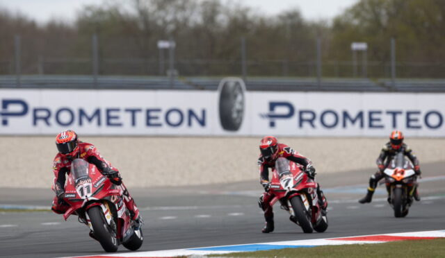 Three motorcycle racers lean into a curve on a track, with a Prometeon banner in the background.