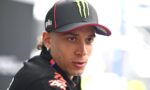 Close-up of a man wearing a black Monster Energy cap, looking off to the side with a focused expression.