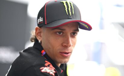 Close-up of a man wearing a black Monster Energy cap, looking off to the side with a focused expression.
