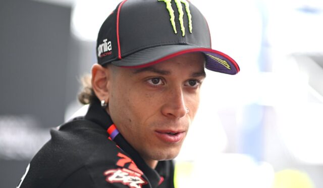 Close-up of a man wearing a black Monster Energy cap, looking off to the side with a focused expression.
