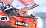 Close-up of a race car driver wearing a red helmet with Lenovo branding