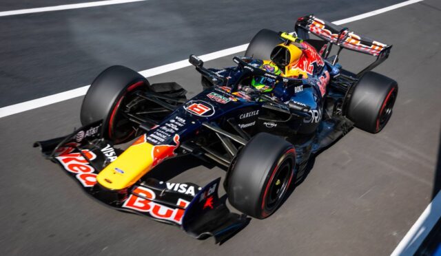 Red Bull Racing Formula 1 car on a race track with sponsor logos visible on the body and front wing, viewed from above.