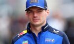 Portrait of a man in Oracle Red Bull Racing blue uniform, cap, and jacket, looking at the camera at a sports event