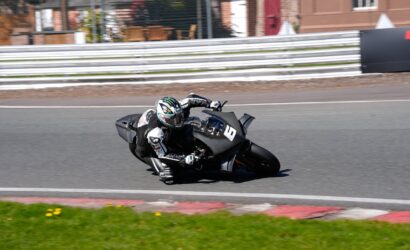 Motorcycle racer in full gear leaning into a turn on a race track, bike number 8.
