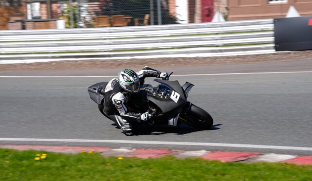 Motorcycle racer in full gear leaning into a turn on a race track, bike number 8.