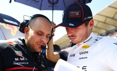 Oracle Red Bull Racing engineer and driver lean in over a sheet, discussing strategy.