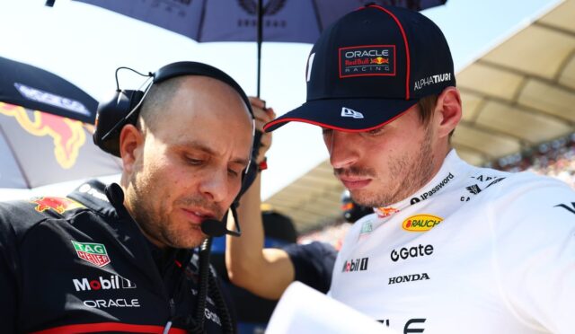 Oracle Red Bull Racing engineer and driver lean in over a sheet, discussing strategy.
