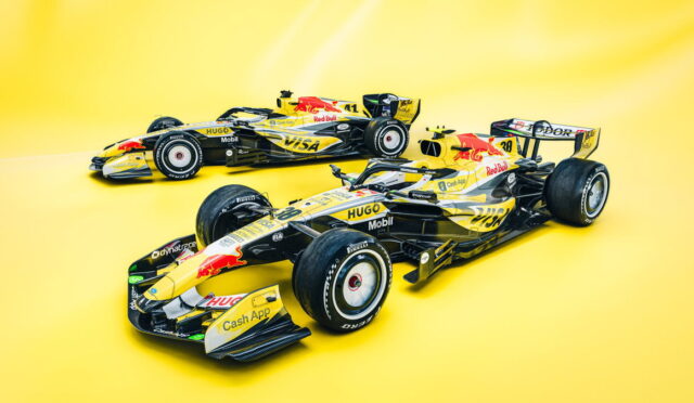 Two Red Bull Racing Formula 1 cars on a solid bright yellow backdrop, angled as if ready to race (yellow and black livery).