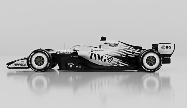 Side view of a black-and-white Formula 1 race car on a reflective surface with sponsor logos visible along the bodywork.