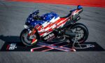 Aprilia racing motorcycle with star-spangled red, white, and blue livery on a track stand.