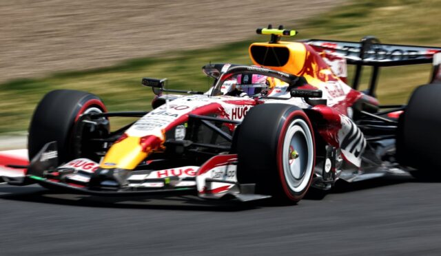 Red Bull Racing Formula 1 car speeding on a race track, showcasing red, white, and yellow livery and sponsor logos.