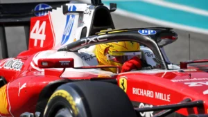 Red Formula 1 race car speeding on track, driver in a yellow helmet with sponsor logos visible across the car.3a8️👨‍🚀