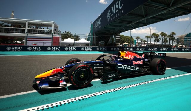 Formula 1 car on a race track near the pit lane with MSC Cruises banners along the barrier.