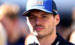 Close-up of a man in a blue cap with Oracle Red Bull Racing patch, speaking into a microphone during an interview.