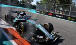 Formula 1 car taking a sharp turn on the Miami circuit, blue run-off and barriers along the track.