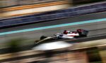 Formula 1 car speeding along a race track with blurred colorful barriers in the background.