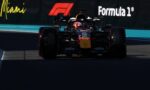 Front view of a Red Bull Formula 1 car racing toward the camera on a track with Miami/Formula 1 banners in the background