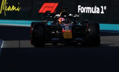 Front view of a Red Bull Formula 1 car racing toward the camera on a track with Miami/Formula 1 banners in the background