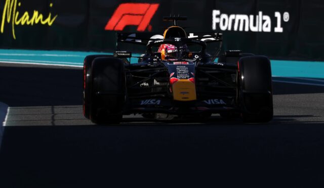 Front view of a Red Bull Formula 1 car racing toward the camera on a track with Miami/Formula 1 banners in the background