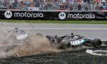 Two Formula 1 cars crash on a gravel runoff, dust and debris spraying as spectators watch behind a chain-link fence and a Motorola barrier.”,”F1 cars collide near the track edge, kicking up dirt while fans photograph from behind the fence and sponsor banners.”,”Race cars in a high-speed crash on the runoff area, crowd watching intently from behind the fence.
