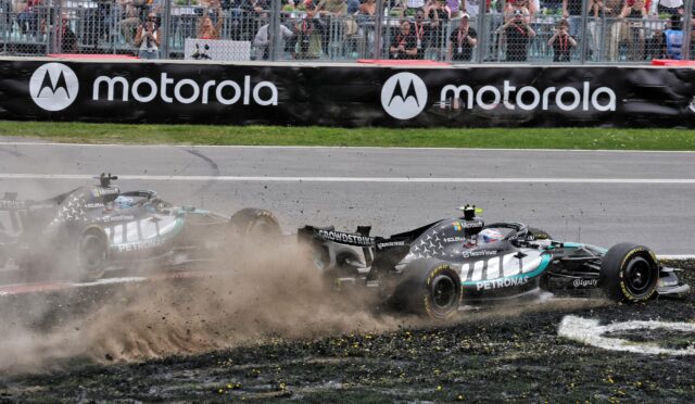 Two Formula 1 cars crash on a gravel runoff, dust and debris spraying as spectators watch behind a chain-link fence and a Motorola barrier.”,”F1 cars collide near the track edge, kicking up dirt while fans photograph from behind the fence and sponsor banners.”,”Race cars in a high-speed crash on the runoff area, crowd watching intently from behind the fence.