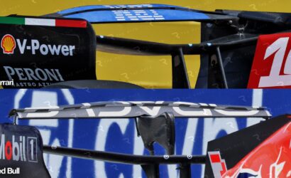 Close-up of race car rear wings with sponsor logos including V-Power, Peroni, Ferrari, and Red Bull.