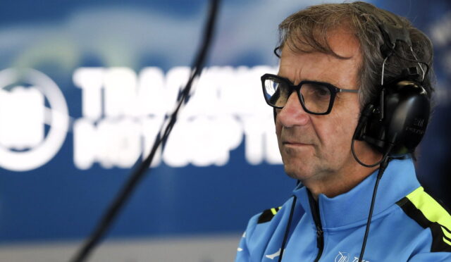 Radio host wearing glasses and headphones in a studio, speaking into a microphone.