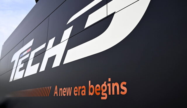 Close-up of a dark wall sign with a large white 'Tech' logo and the orange tagline 'A new era begins'.