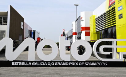Large white MotoGP sign in a race paddock with 'Estrella Galicia 0,0 Grand Prix of Spain 2026' on the base.