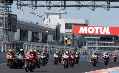 Motorcycle racers sprinting off the starting line on a straight track with a large Motul banner in the background