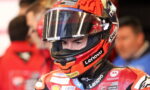 MotoGP rider wearing a red helmet with Lenovo and Motorola logos, close-up portrait in the pit area.