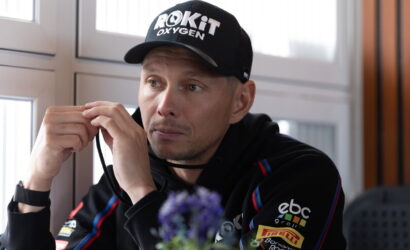 Man wearing a black cap labeled 'ROKiT Oxygen' adjusts a strap while seated indoors.