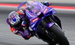 MotoGP rider leaning into a corner on a purple Yamaha race bike with number 43