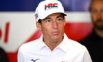 Man in a white polo shirt and a Honda Racing cap at a media event.