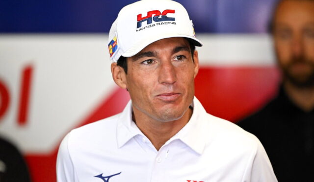 Man in a white polo shirt and a Honda Racing cap at a media event.