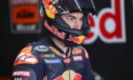 Close-up of a motorcycle racer wearing a Red Bull helmet and KTM racing suit, concentrating ahead