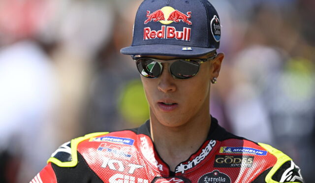 Rider wearing a Red Bull cap and reflective sunglasses in a red and black racing suit. liq Boa border not included