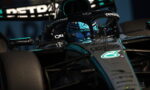 Mercedes-AMG Petronas Formula 1 car in teal and black, driver visible in the cockpit with blue helmet, close-up on front and halo protection.