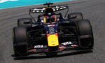 Front-on view of a Red Bull Racing Formula 1 car speeding on a track, with sponsor logos visible on the nose and wings.