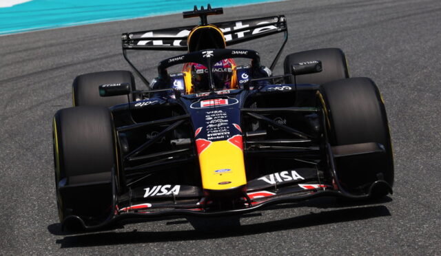 Front-on view of a Red Bull Racing Formula 1 car speeding on a track, with sponsor logos visible on the nose and wings.